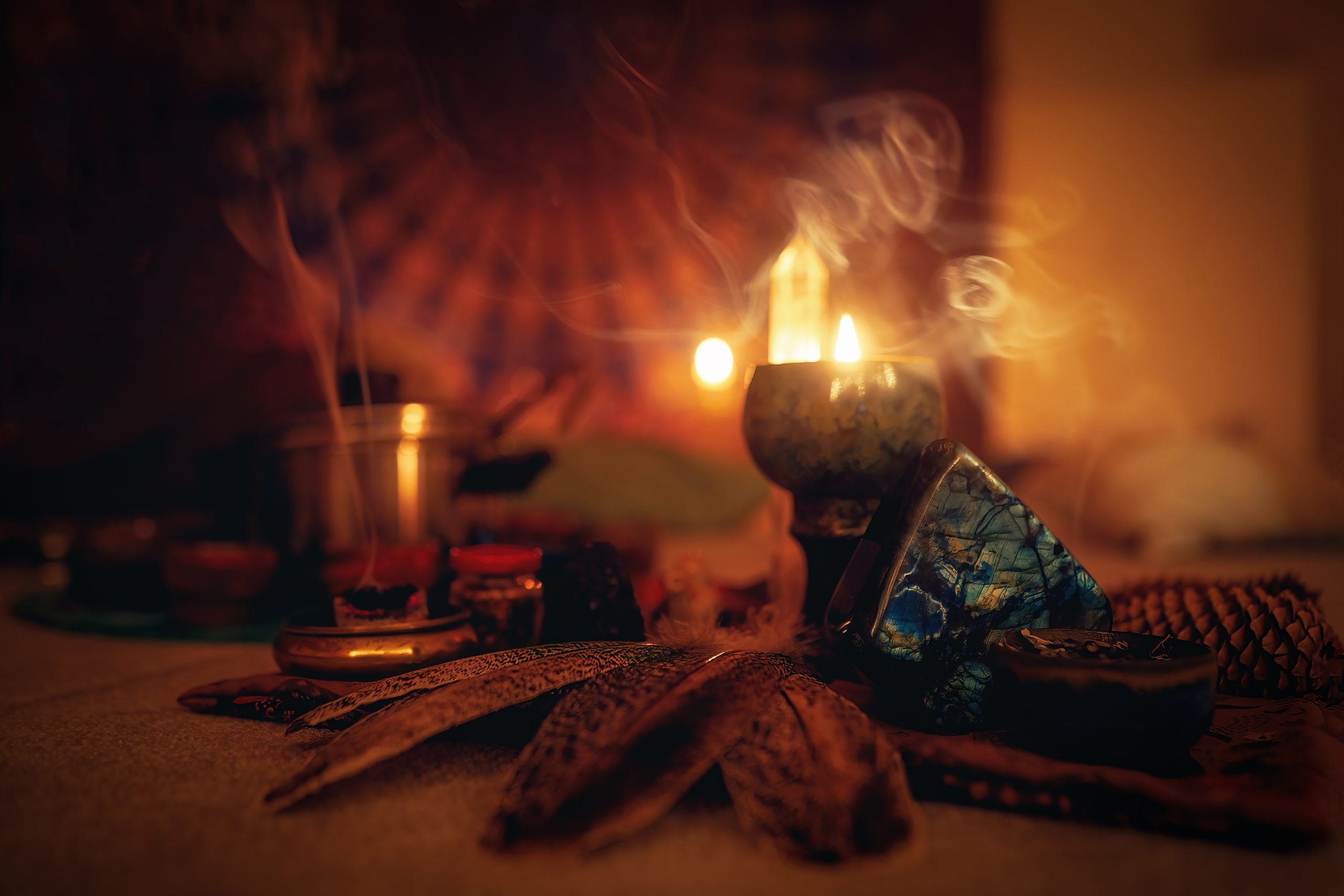Candles flicker beside incense, crystals, and natural elements, creating a warm, mystical atmosphere.