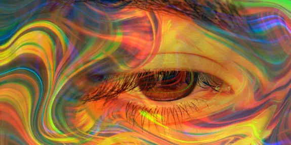 A close-up of an eye surrounded by vibrant, swirling colors and abstract patterns.