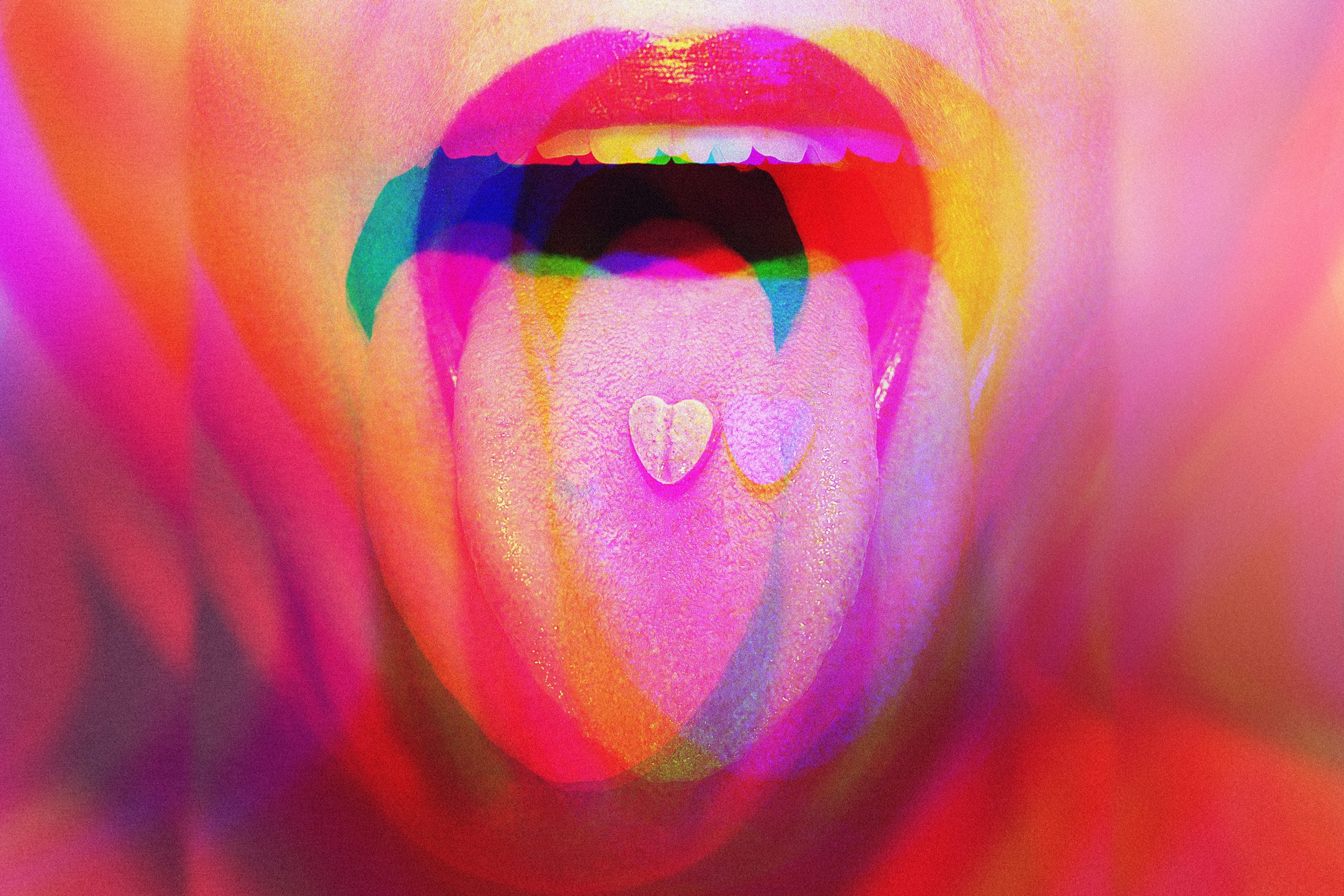 Colorful, abstract close-up of a mouth with a tongue showing two heart-shaped candies, surrounded by vibrant hues.