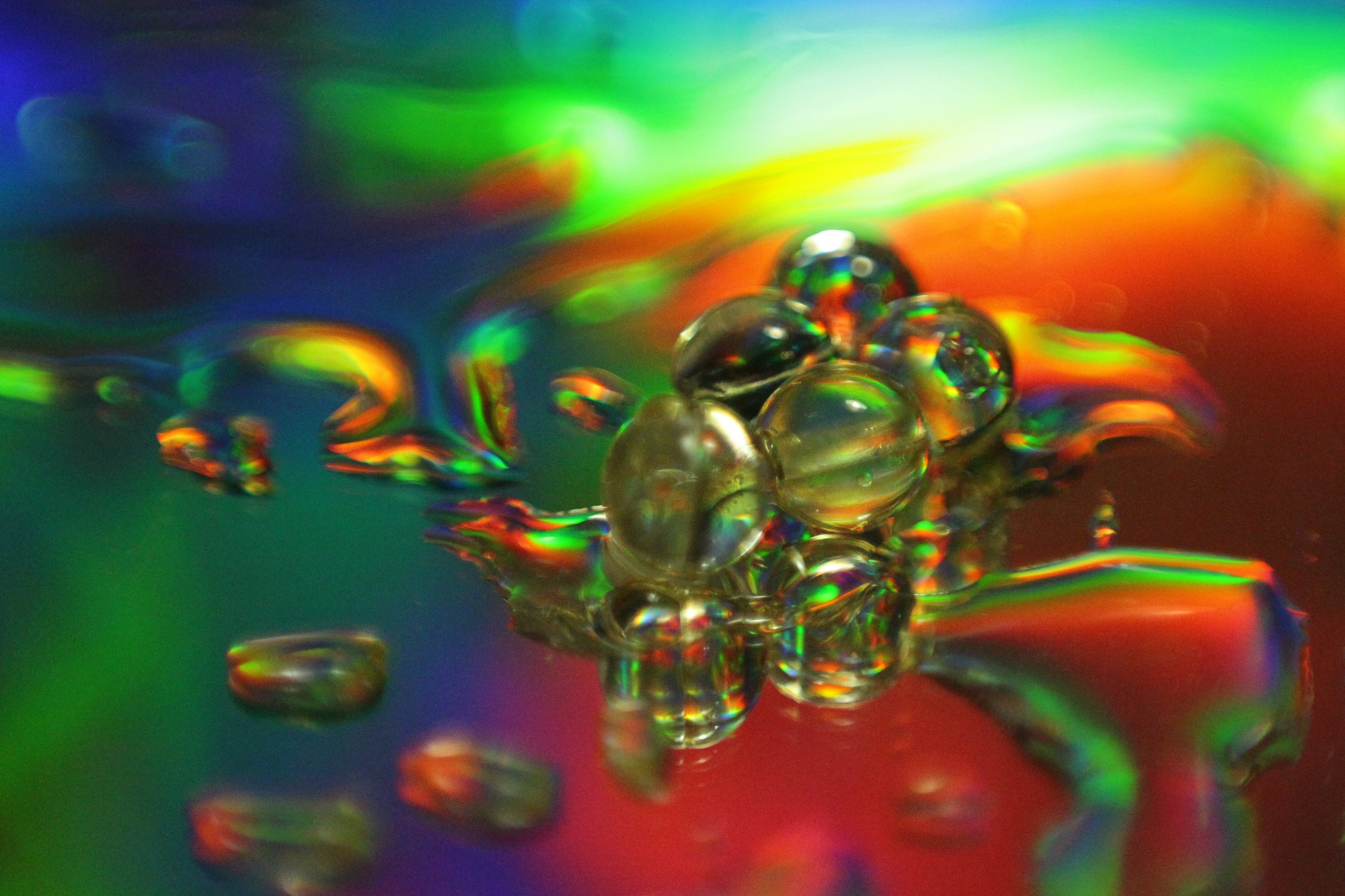 Colorful bubbles float in a vibrant, abstract background of swirling hues, creating a mesmerizing visual effect.