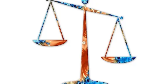 Colorful scales of justice with ornate blue and orange patterns, symbolizing balance and fairness.