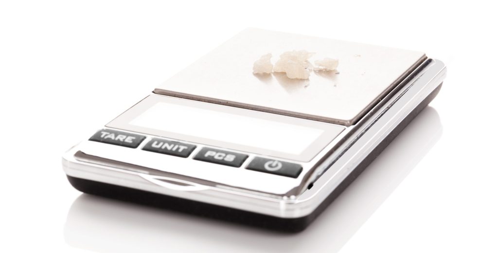Digital scale displaying a small amount of white substance on its weighing platform.