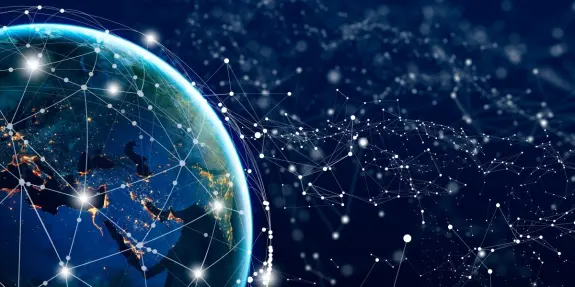 Earth illuminated at night, surrounded by a network of glowing connections against a dark, starry background.