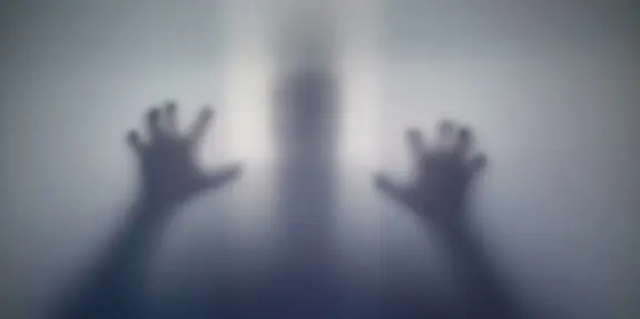Faint silhouette of a person with hands pressed against a translucent surface, creating a haunting, ethereal effect.