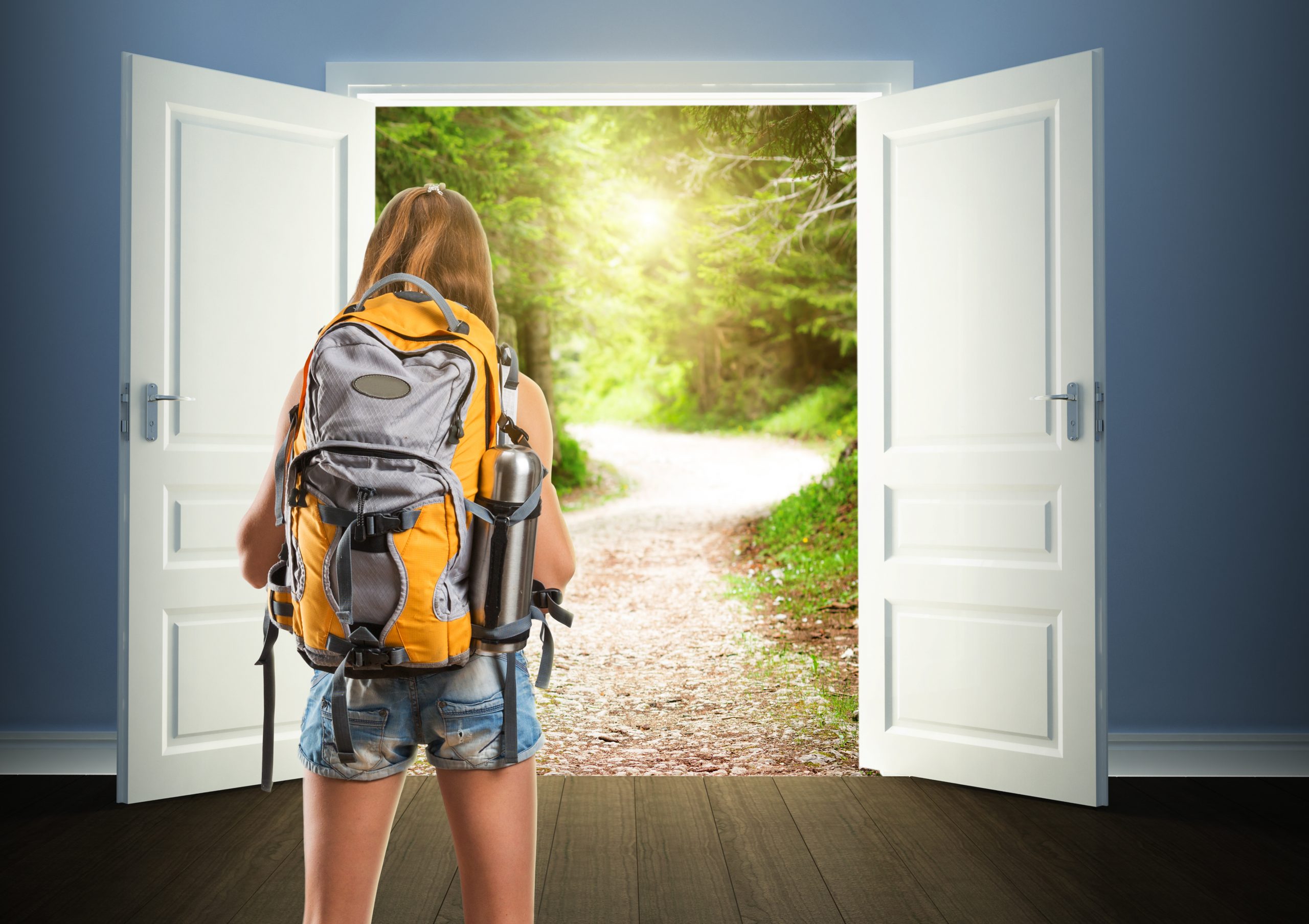 A girl with a backpack stands at open doors, looking out at a sunlit forest path.