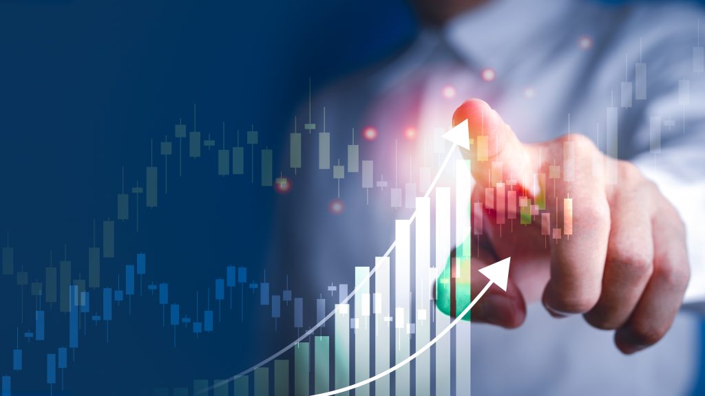A hand points at an upward-trending graph, symbolizing growth and financial success against a blue background.