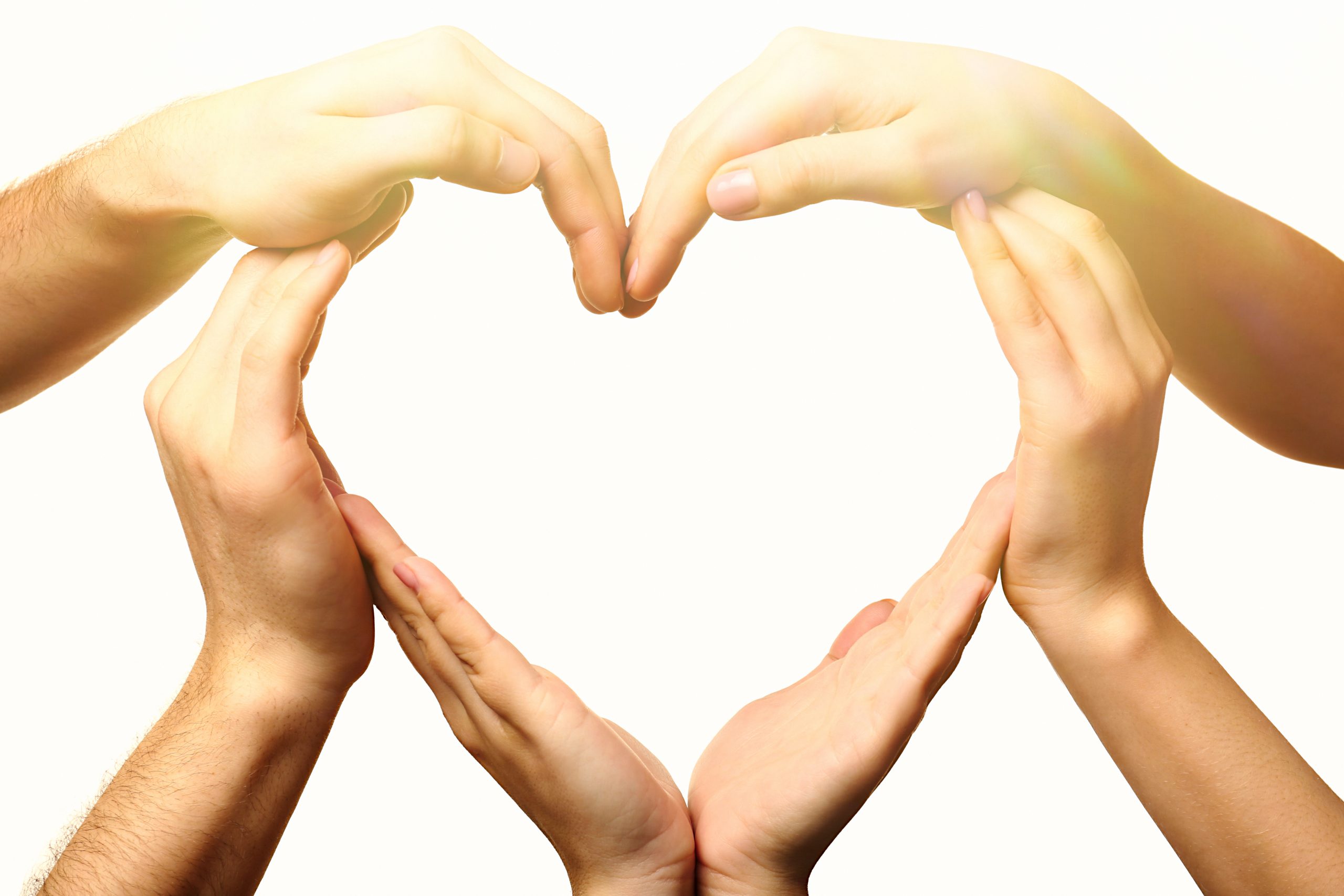 Hands forming a heart shape against a bright, light background, symbolizing love and unity.