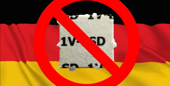 A torn piece of paper with "1V1CD" is overlaid on a German flag, marked with a red prohibition sign.