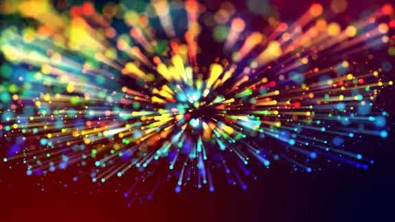 Colorful bursts of light radiate outward against a dark background, creating a dynamic, vibrant explosion effect.