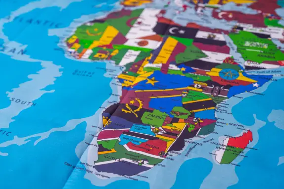 Colorful map of Africa highlighting countries with distinct borders and symbols, set against a blue background.