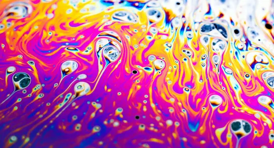 Vibrant swirls of purple, orange, and blue create a mesmerizing abstract pattern with bubbles throughout.