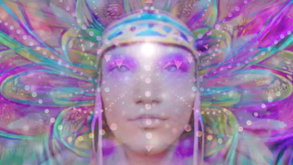 A serene face adorned with a colorful headdress, surrounded by vibrant patterns and soft, glowing lights.