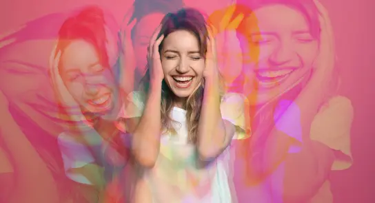 A joyful woman with long hair smiles broadly, holding her head, surrounded by vibrant, overlapping colors.