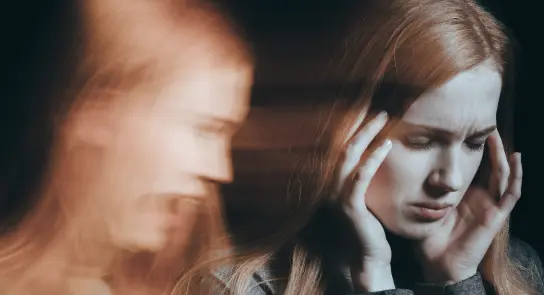 A distressed woman holds her head, with a blurred figure in the background expressing anguish.