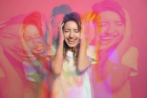 A joyful woman covers her ears, smiling, with a vibrant pink background and multiple overlapping images of her expression.
