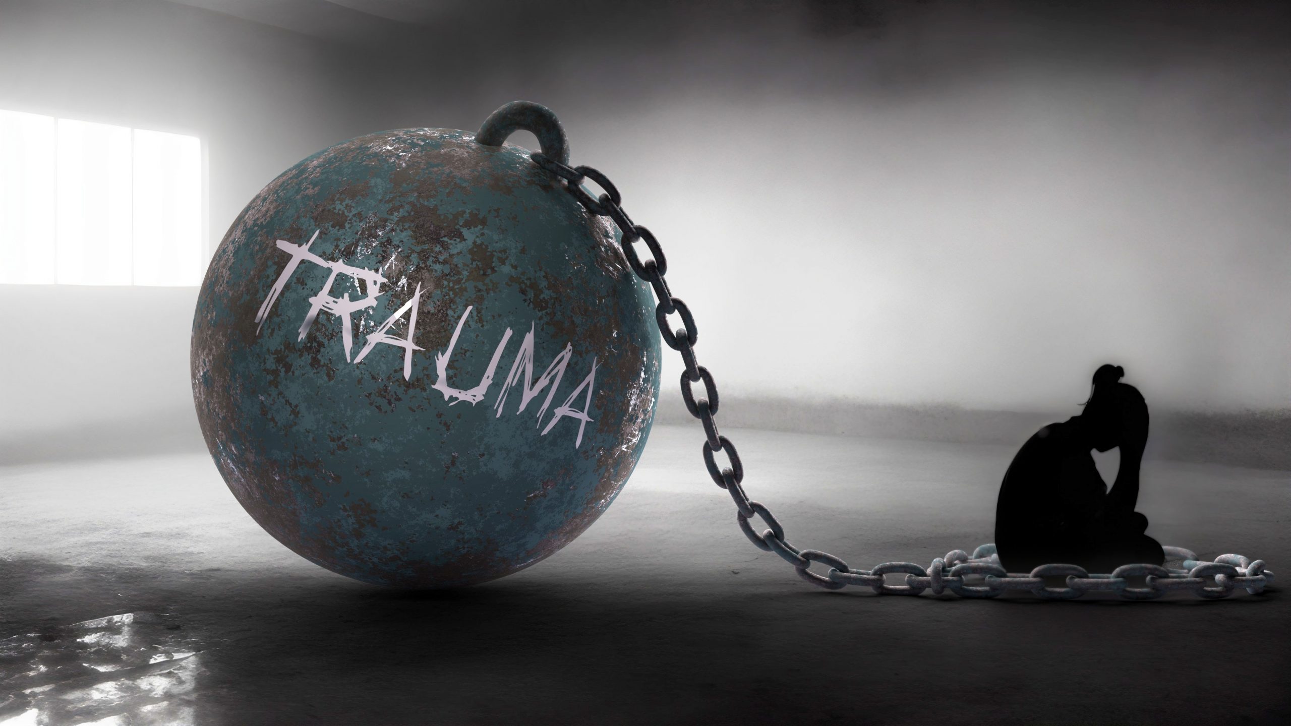 A large, rusted ball labeled "TRAUMA" is chained to a silhouette of a person sitting in a dark, foggy space.