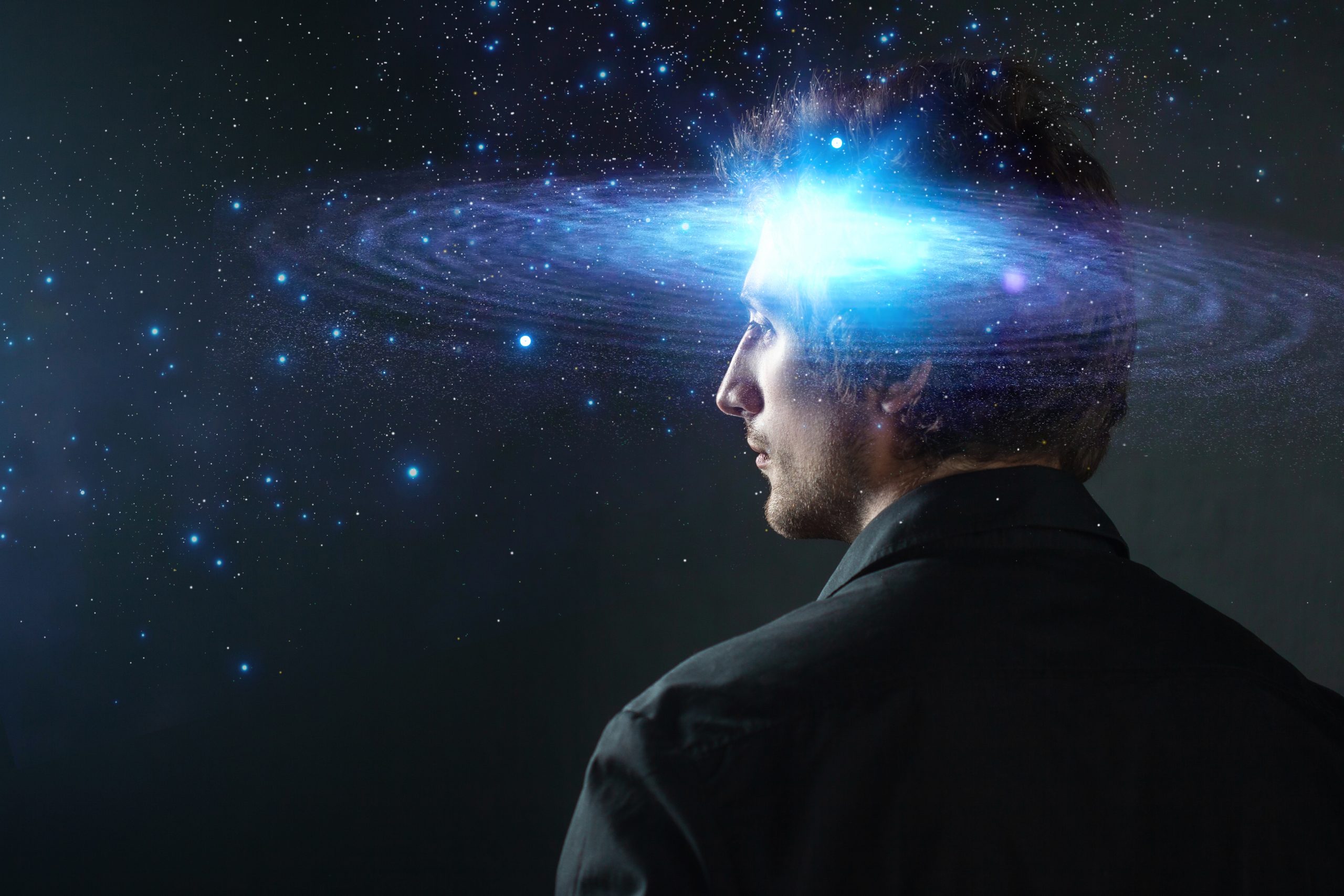 A man in profile with a galaxy swirling above his head, symbolizing creativity and imagination.