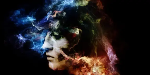 A profile of a face surrounded by vibrant, swirling colors and ethereal smoke against a dark background.