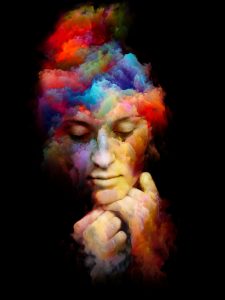 A serene face emerges from vibrant, swirling colors, blending hues of red, blue, and yellow against a dark background.