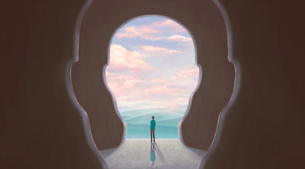 A silhouette of a head frames a person gazing at a serene landscape with mountains and a pastel sky.