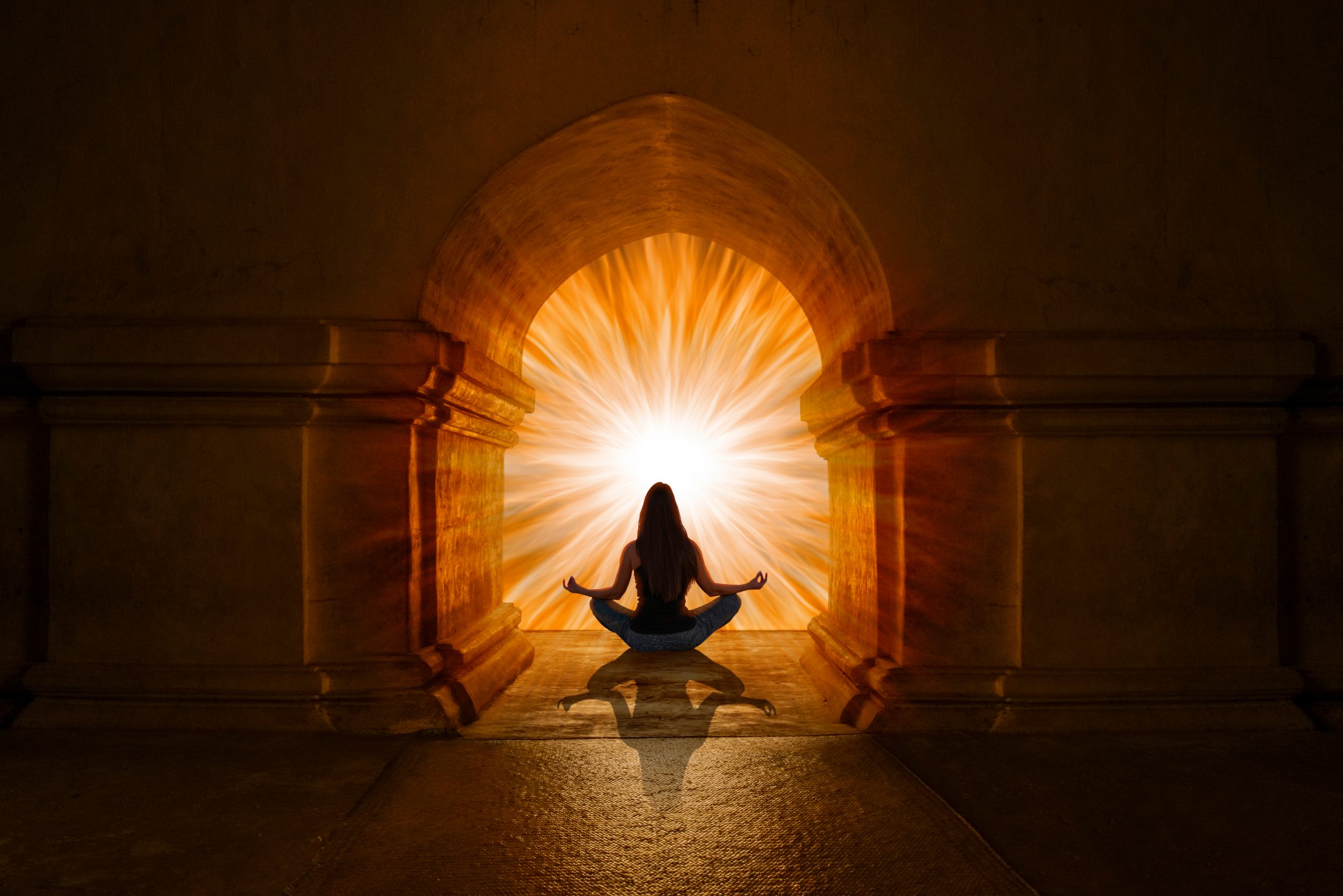A silhouette of a person meditating in front of a glowing archway, radiating warm light and energy.