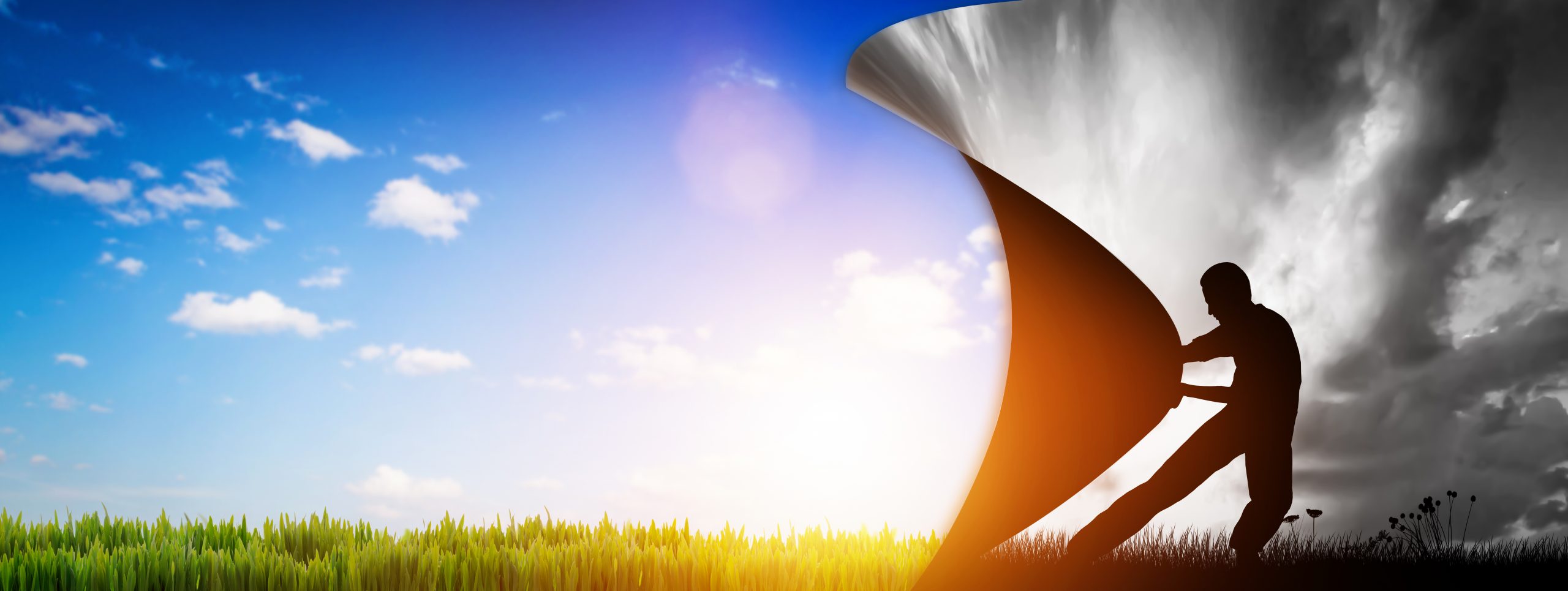 A silhouette of a person pulling back a large curtain to reveal a bright sky and green grass.