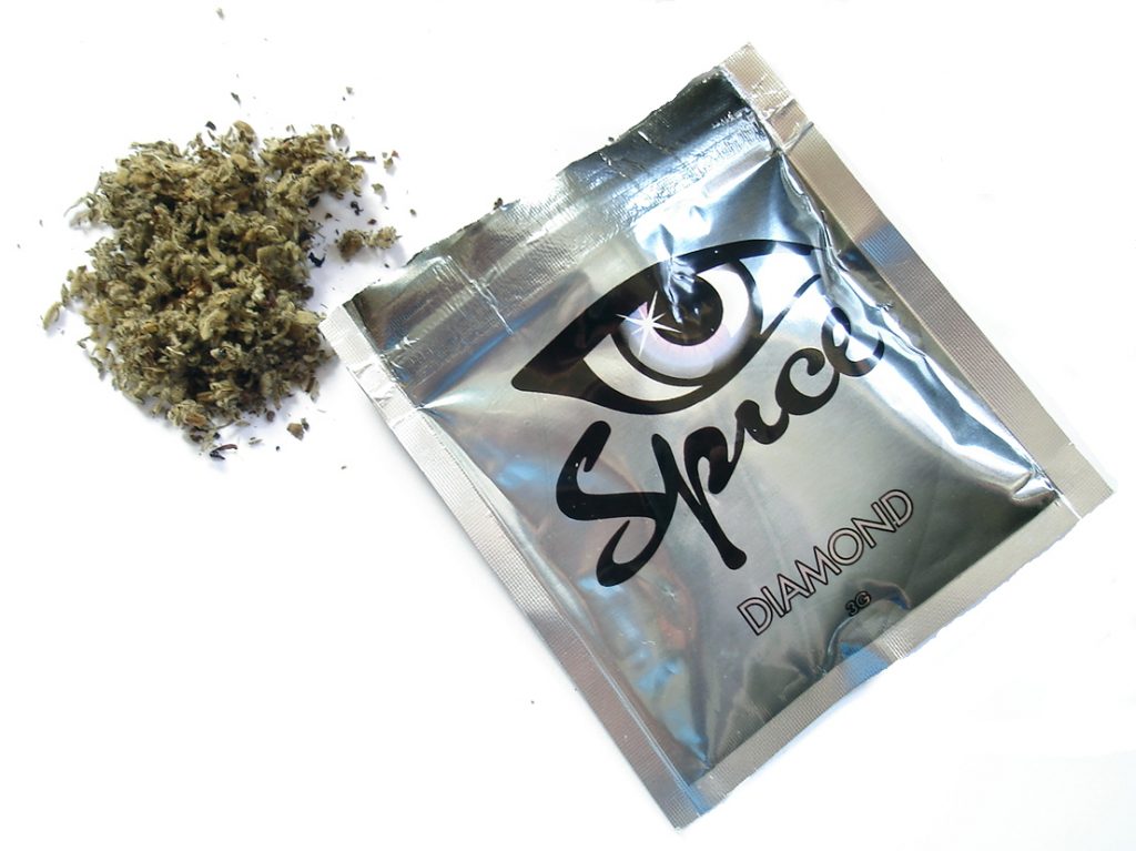 Silver pouch labeled "Spice Diamond" next to a small pile of dried herbal material.