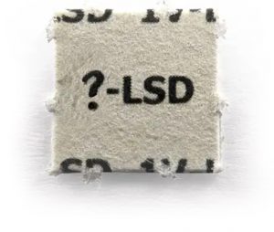 Small square blotter paper with the text "?-LSD" printed in bold black letters on a white background.
