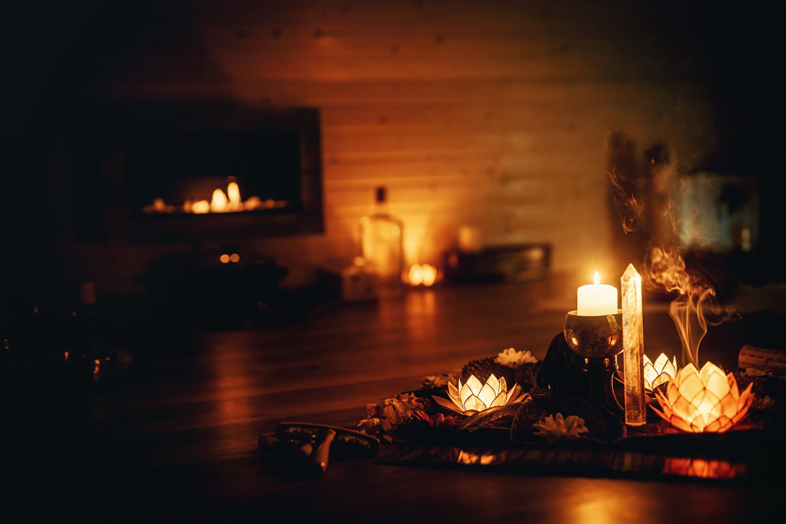 Soft candlelight illuminates a serene setting with lotus flowers and incense, creating a calming atmosphere.