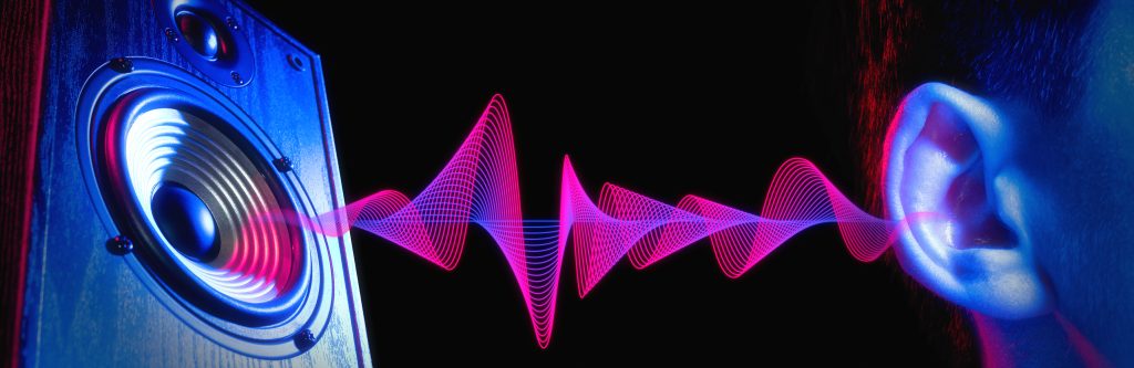 A speaker emits vibrant sound waves, reaching an ear against a dark background, highlighting the connection between sound ...