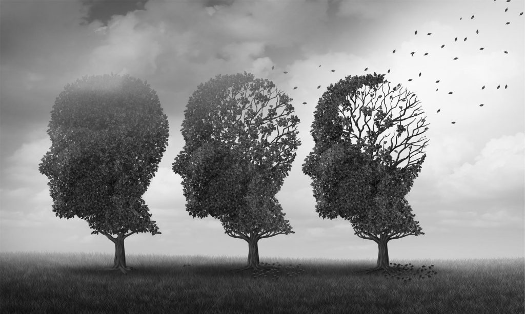 Three tree silhouettes shaped like human heads, gradually losing leaves and branches against a cloudy sky.