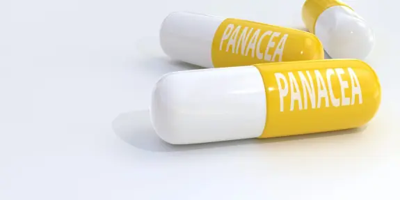 Three yellow and white capsules labeled "PANACEA" on a clean, white surface.
