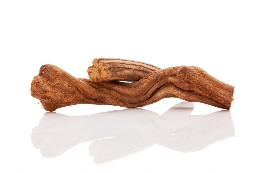 Two intertwined pieces of smooth, brown driftwood on a reflective surface.