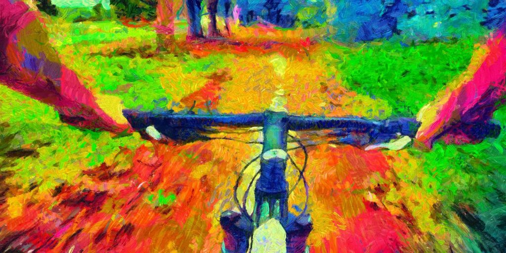 Vibrant, colorful view from a bike handlebar on a lush, winding trail surrounded by greenery.