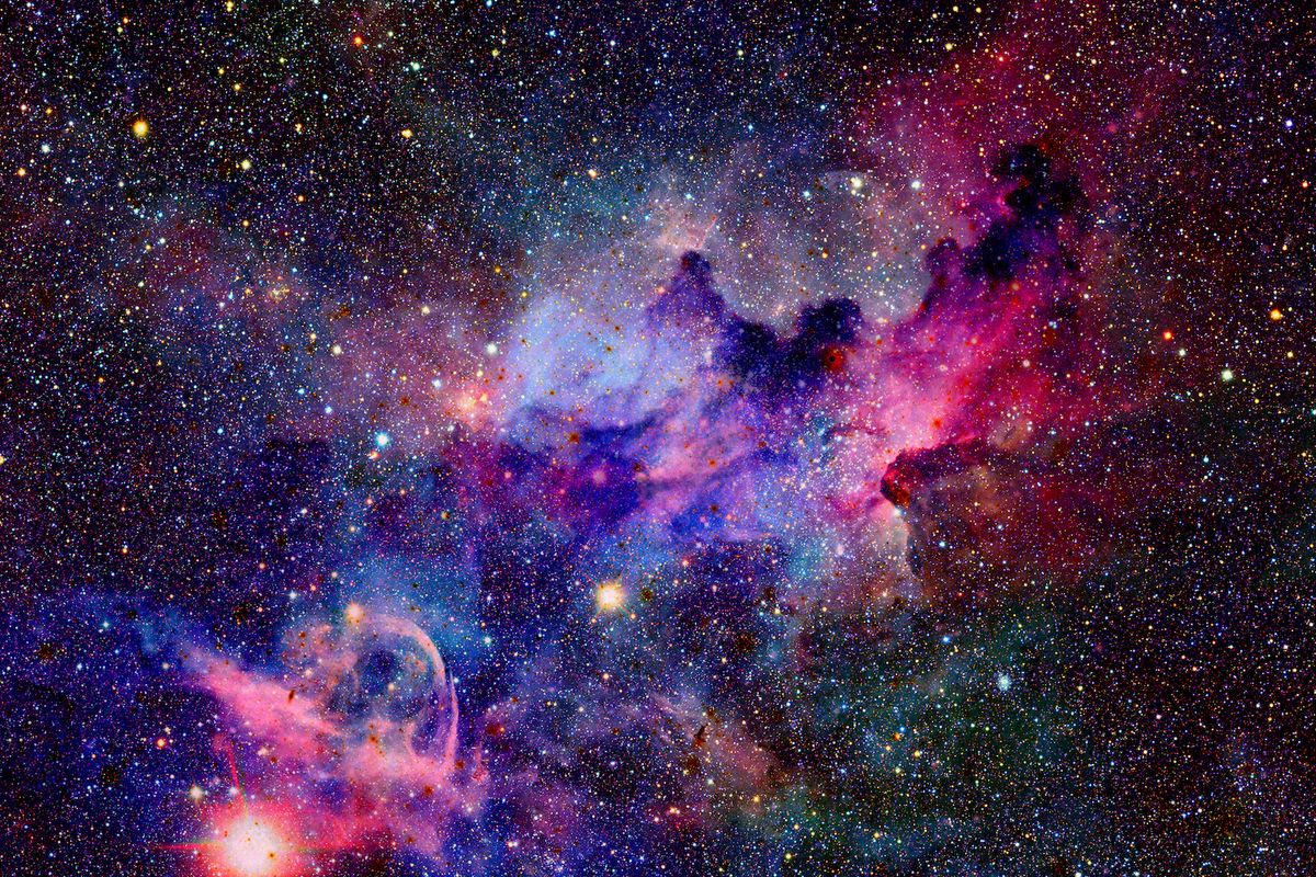 Vibrant cosmic scene filled with colorful nebulae, stars, and swirling gases against a dark backdrop of space.