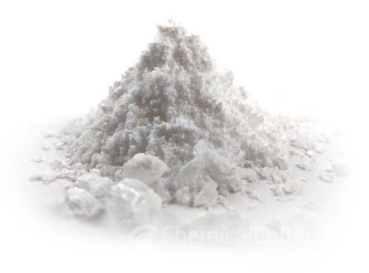 White crystalline powder piled on a surface, with larger crystal fragments scattered nearby.
