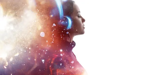A woman with headphones, eyes closed, surrounded by a colorful, cosmic background of light and sparkling elements.