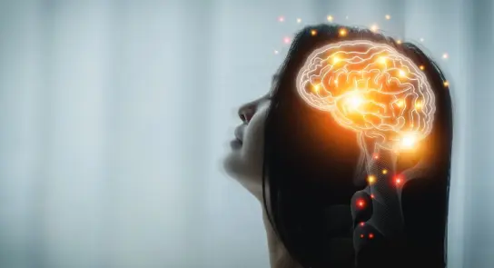 Woman's silhouette with a glowing brain illustration, symbolizing thought and creativity against a soft background.