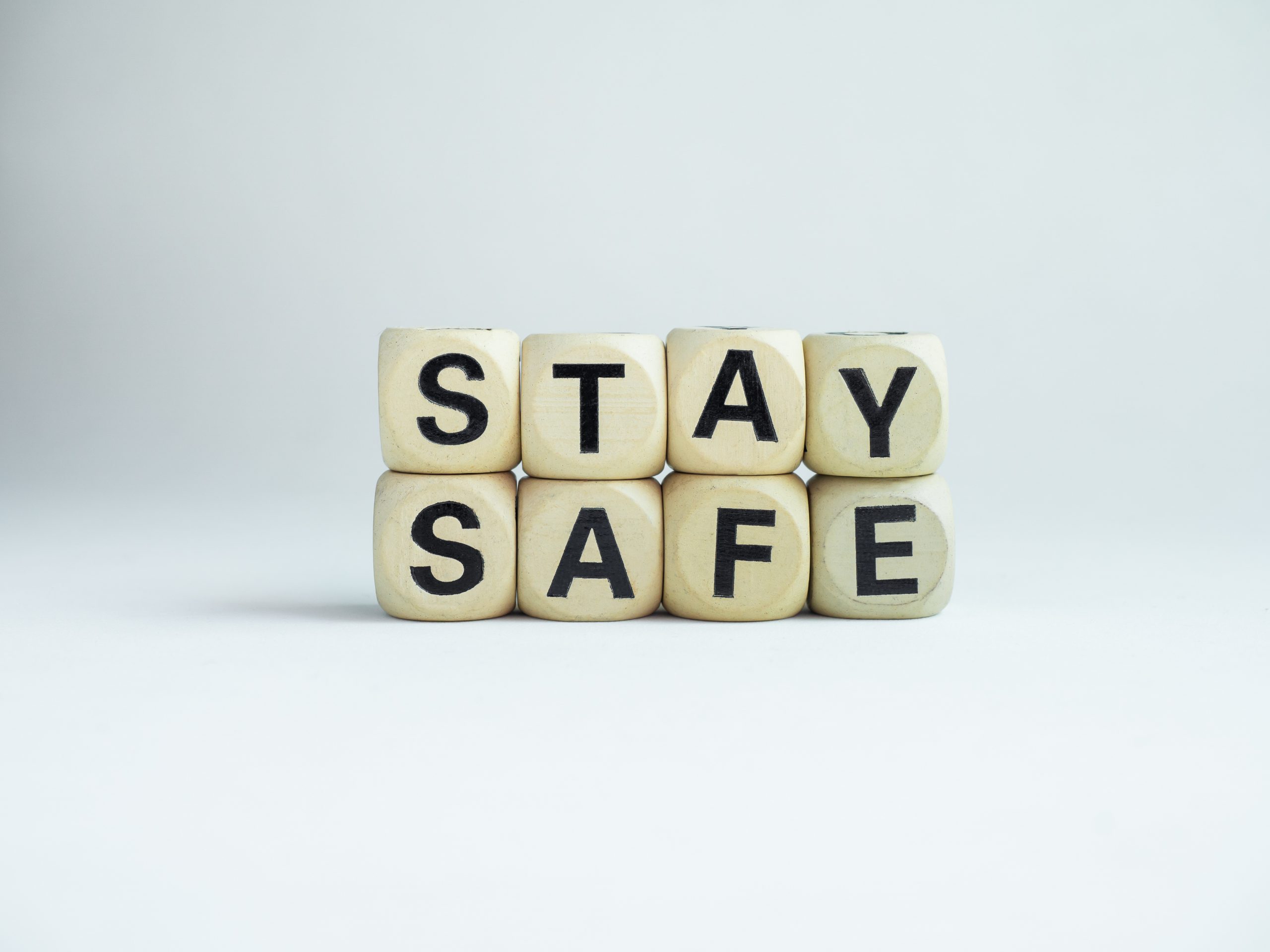 Wooden blocks arranged to spell "STAY SAFE" against a light background.